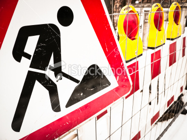 stock-photo-22352517-men-at-work-sign
